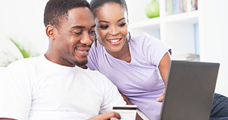Couple on laptop using debit card